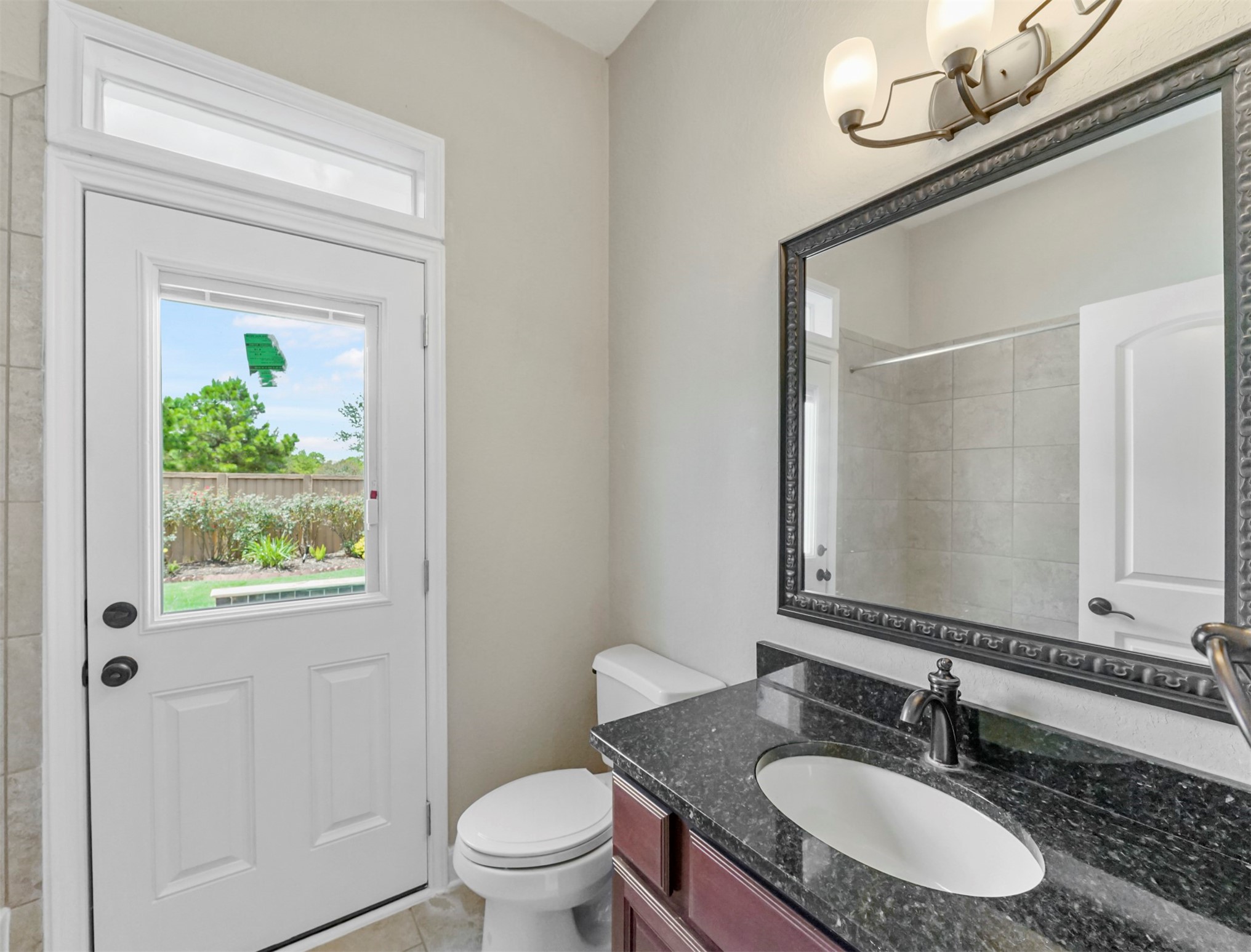 9915 Rochs Hill Court Katy, TX 77494 - Photo 15 of 32 a bathroom with a granite countertop sink a toilet and a mirror