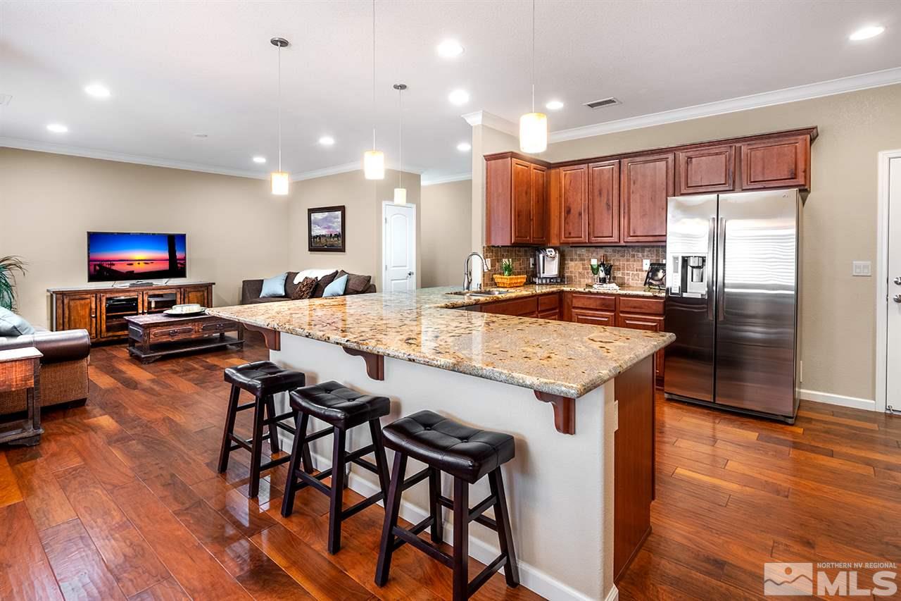 2260 Makenna Drive Reno, NV 89521 - Photo 8 of 27 a kitchen with granite countertop kitchen island stainless steel appliances a stove a sink a refrigerator and chairs