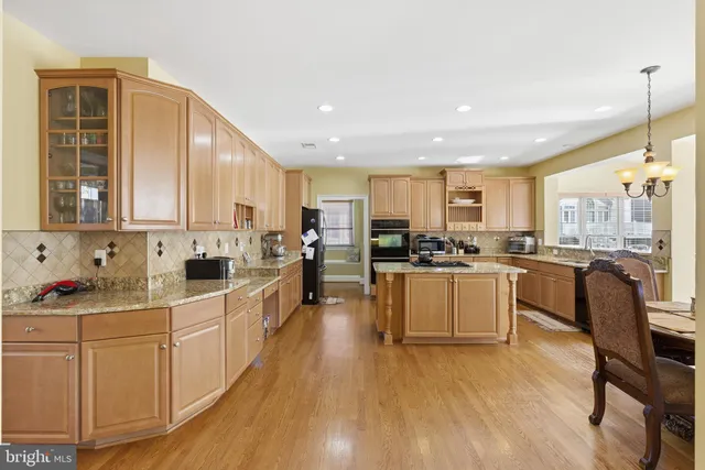 a kitchen with white cabinets stove and white stainless steel appliances