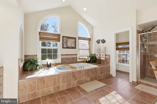 a spacious bedroom with a bed a table and painting on the wall