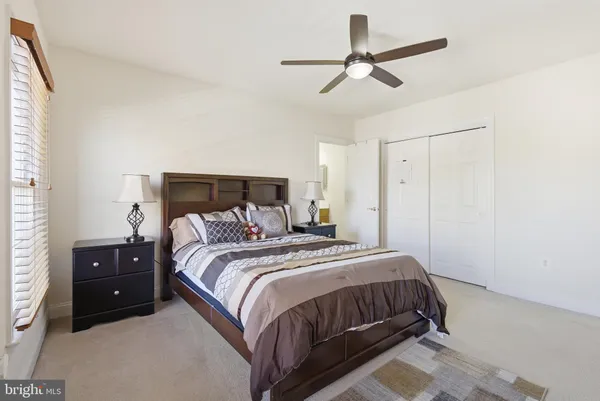 a bedroom with a bed and a ceiling fan