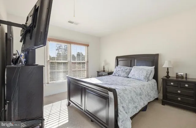 a bedroom with a bed dresser and a window