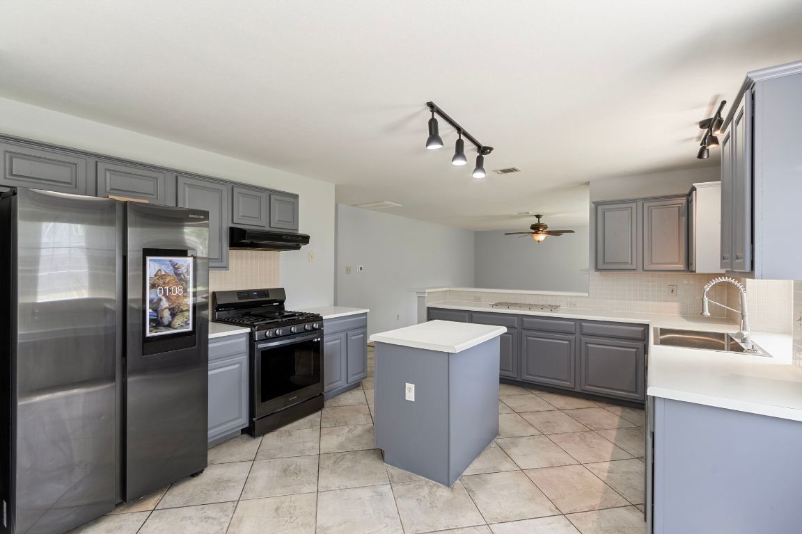 410 Steeplechase Drive Georgetown, TX 78626 - Photo 5 of 15 a kitchen with stainless steel appliances granite countertop a sink counter space cabinets and stainless steel appliances