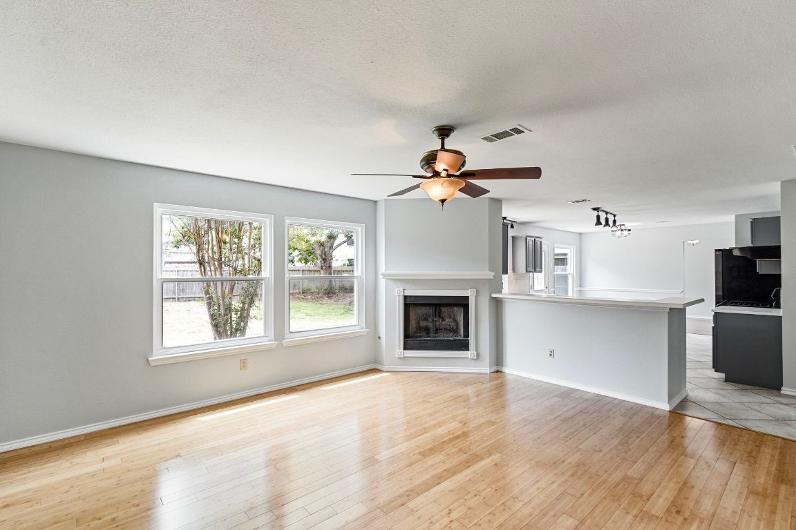 410 Steeplechase Drive Georgetown, TX 78626 - Photo 6 of 15 a view of empty room with wooden floor and fireplace