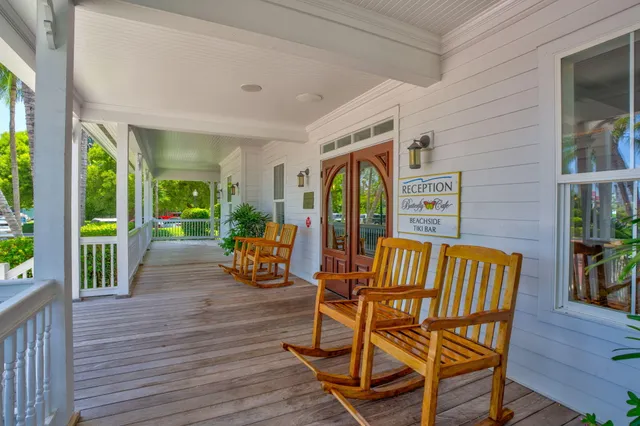 a balcony with wooden floor outdoor seating and yard