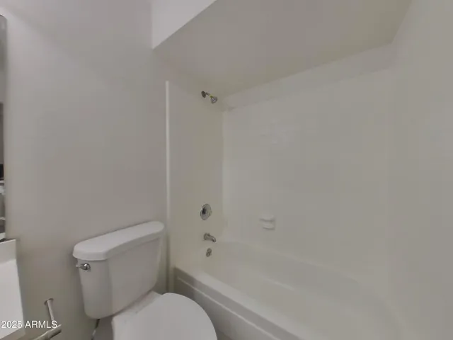 a view of an empty room with wooden floor and closet