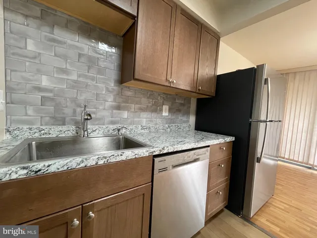 a kitchen with granite countertop a refrigerator and a sink