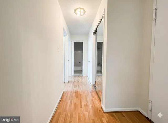 a view of a room with wooden floor and a hallway