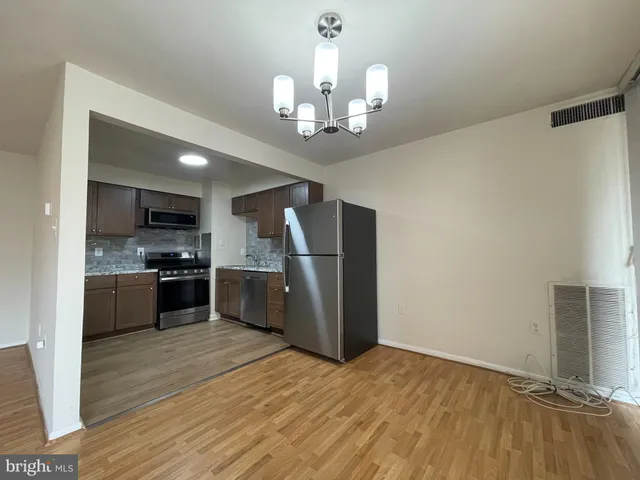 a kitchen with stainless steel appliances granite countertop a refrigerator and a stove top oven