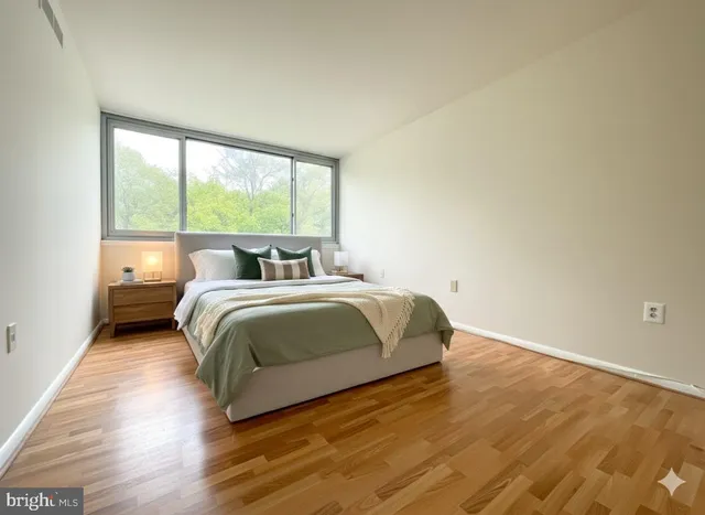 a bedroom with a bed and a large window