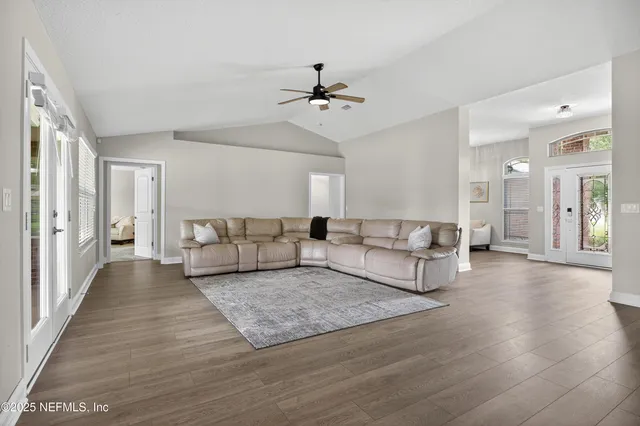 a living room with furniture and a ceiling fan
