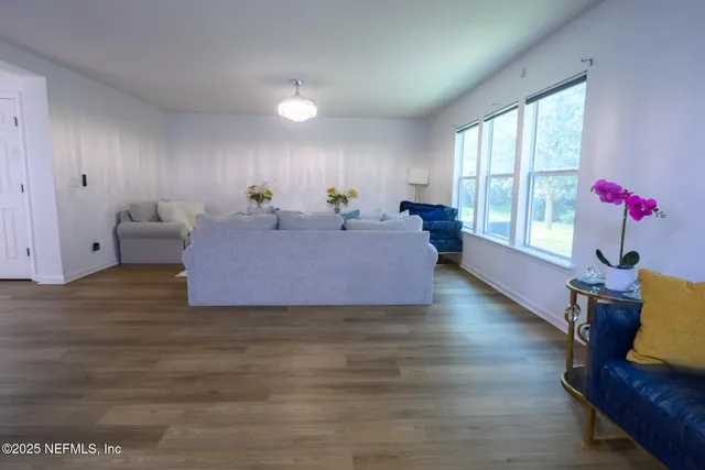 a living room with furniture and wooden floor