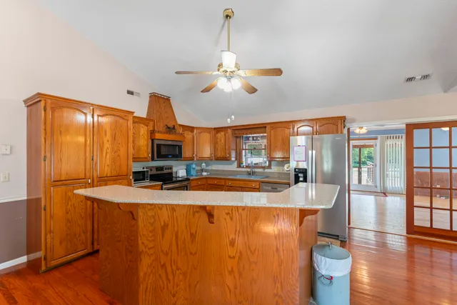 a kitchen with stainless steel appliances granite countertop a sink stove refrigerator and microwave