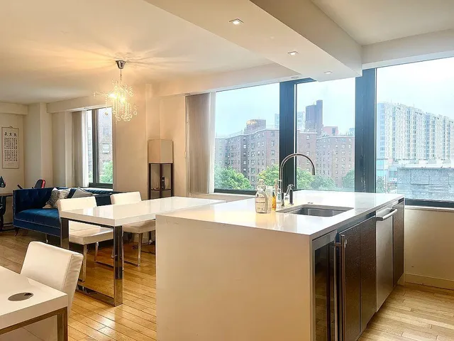 a dining hall with stainless steel appliances granite countertop a sink and a large window