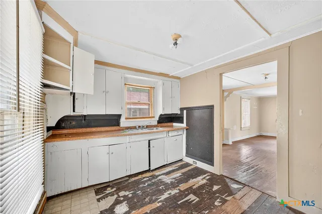 a kitchen with a sink a refrigerator and cabinets