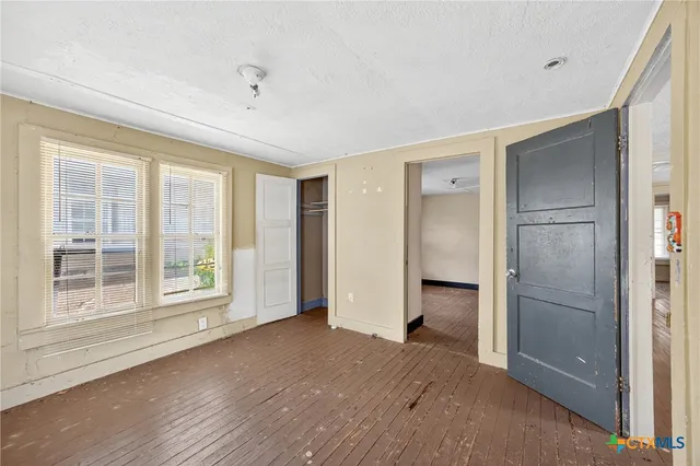 a view of empty room with window and hardwood