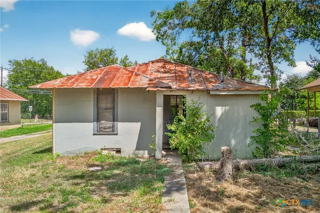 a view of a house with a yard and sitting area