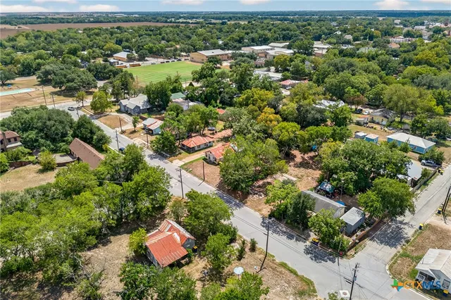 an aerial view of residential house with outdoor space and trees all around