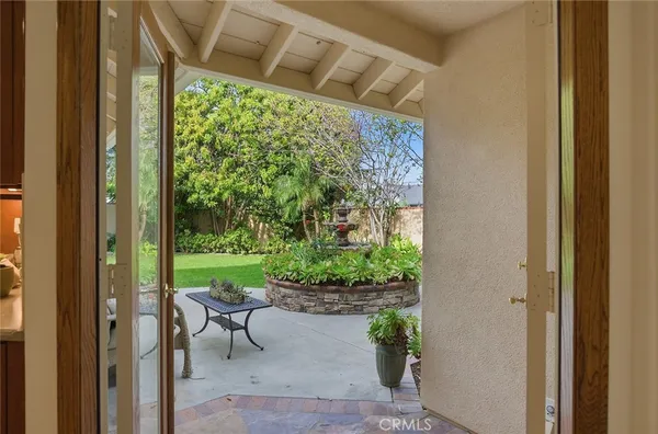 a view of a patio with couple of chairs and potted plants
