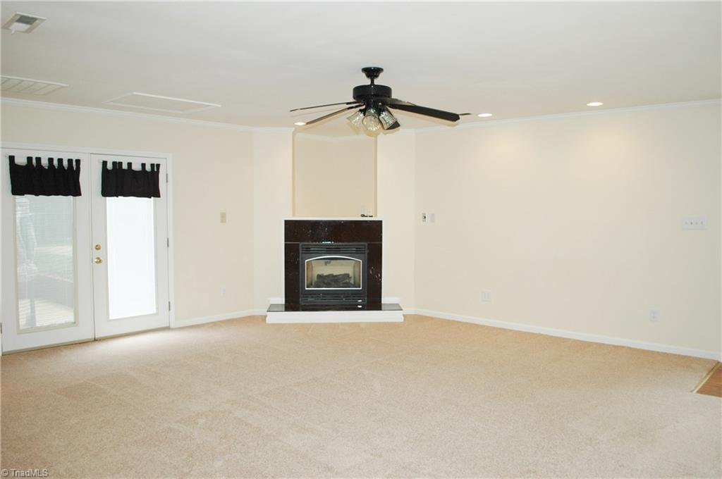 7544 Strawberry Road Summerfield, NC 27358 - Photo 14 of 22 Large den/family room with gas log fireplace recessed lighting and closet space. Also has it's own separate entry to patio.