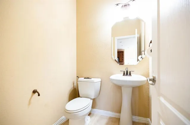 a bathroom with a toilet sink and mirror