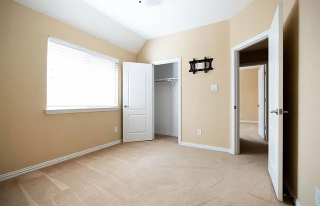 an empty room with windows and closet