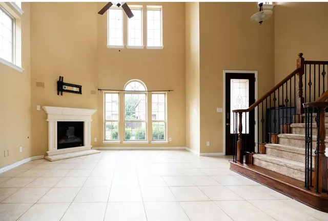 a view of an empty room with fireplace and a window