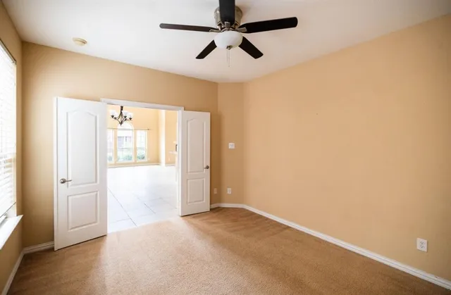 en empty room with wooden floor and ceiling fan