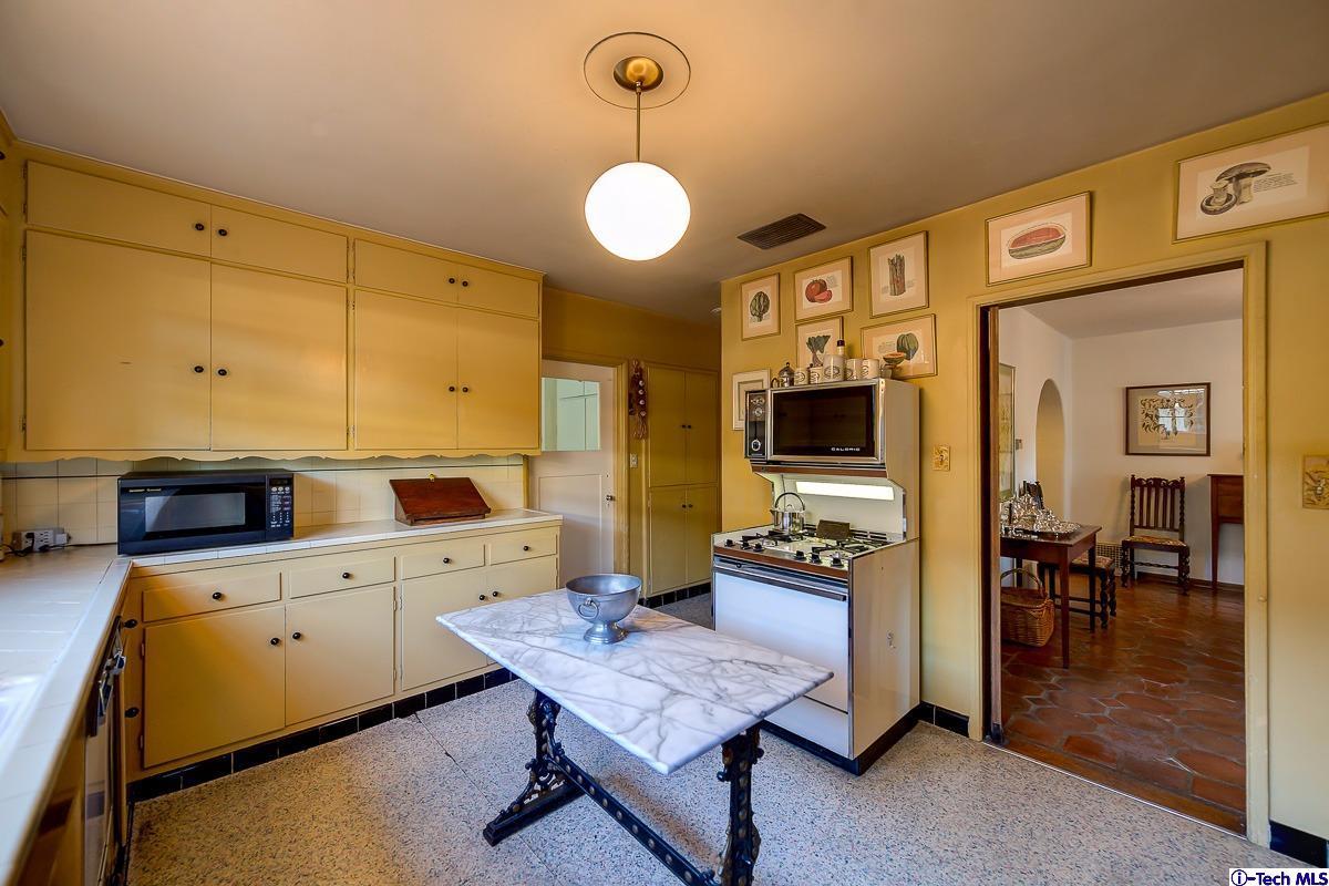 1271 Roanoke Road San Marino, CA 91108 - Photo 23 of 65 a large kitchen with a table chairs and a refrigerator