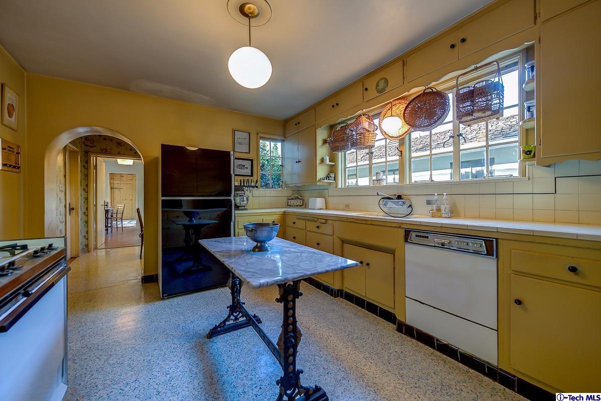 1271 Roanoke Road San Marino, CA 91108 - Photo 24 of 65 a kitchen with a refrigerator a sink dishwasher a stove and a dining table with wooden floor