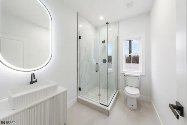 a bathroom with a toilet a sink and a mirror