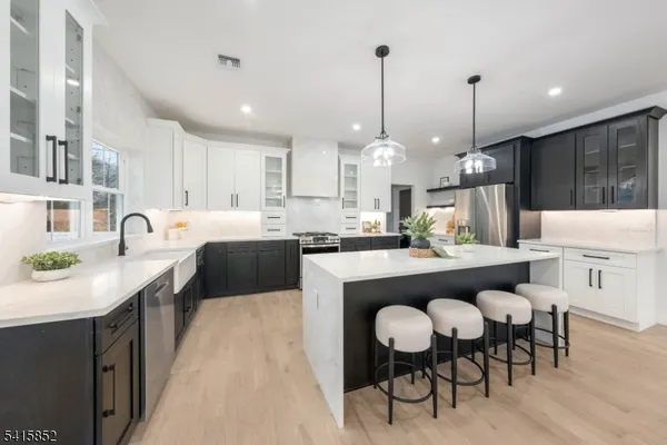 a kitchen with stainless steel appliances granite countertop a table chairs sink refrigerator and cabinets