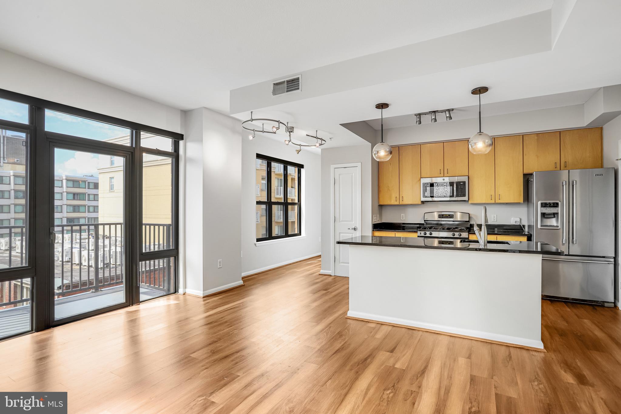 1001 L Street Northwest, Unit 811 Washington, DC 20001 - Photo 13 of 45 a kitchen with stainless steel appliances granite countertop a refrigerator a stove top oven a sink and a large window