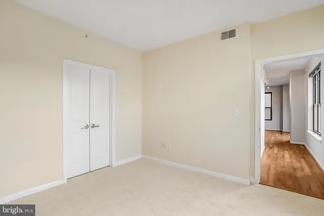 an empty room with windows and closet