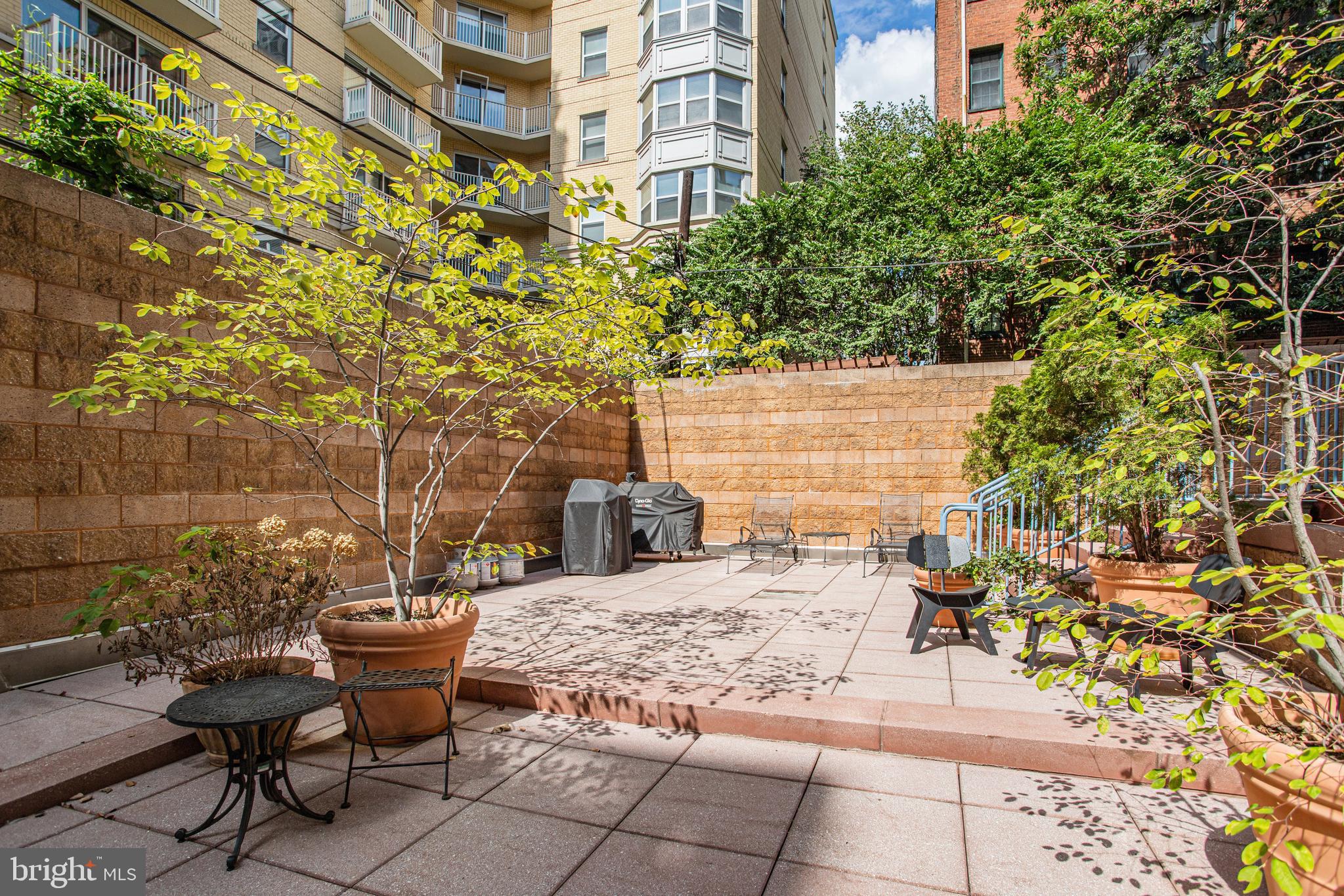 1001 L Street Northwest, Unit 811 Washington, DC 20001 - Photo 28 of 45 a view of a patio with table and chairs and potted plants
