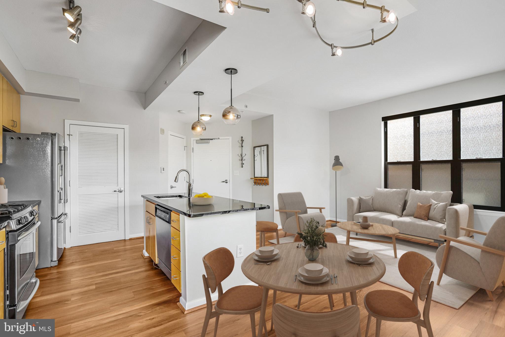 1001 L Street Northwest, Unit 811 Washington, DC 20001 - Photo 7 of 45 a kitchen with stainless steel appliances kitchen island granite countertop a stove a sink dishwasher a dining table and chairs with wooden floor