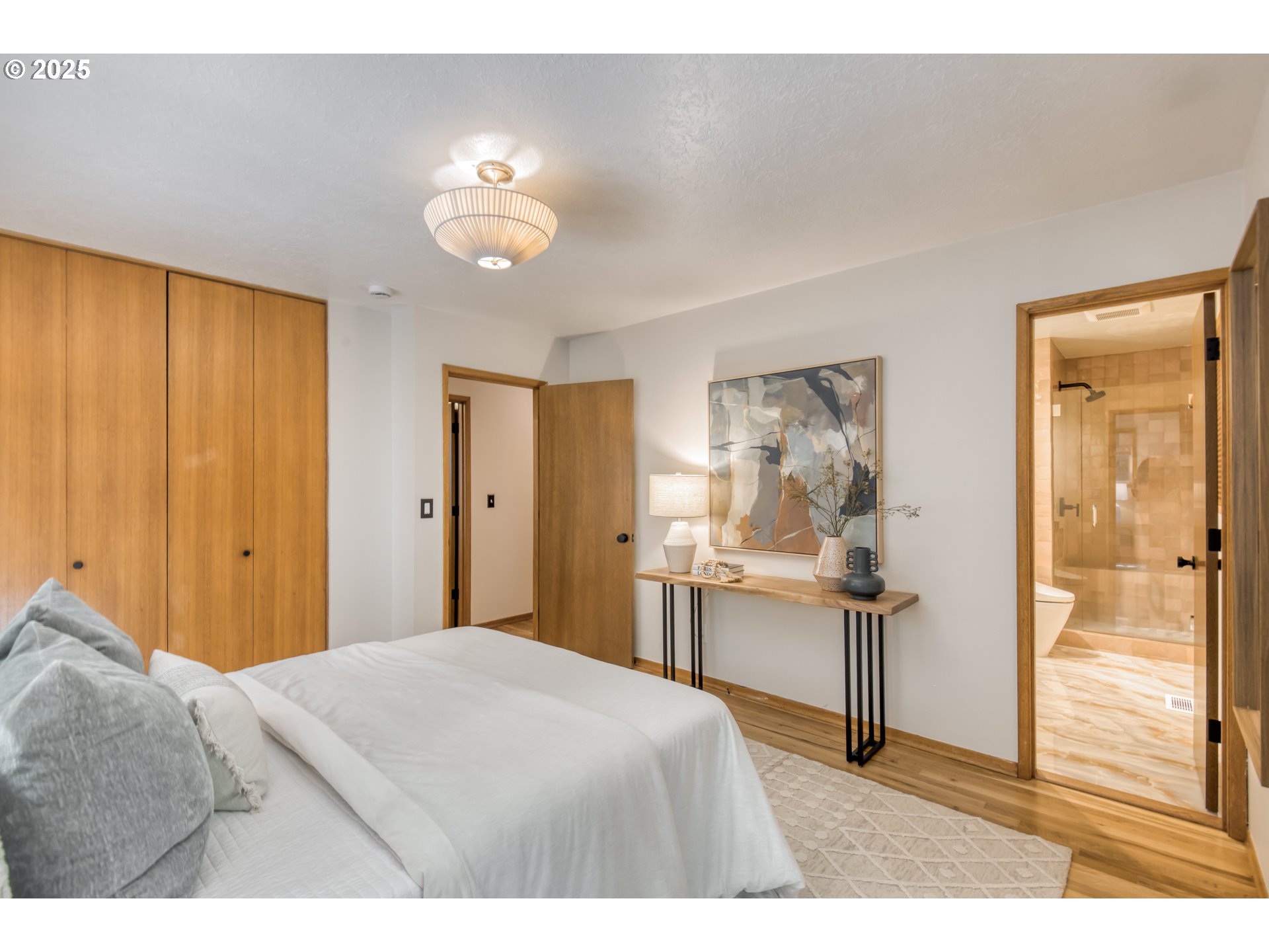 6950 Southeast Ash Street Portland, OR 97215 - Photo 16 of 45 a bedroom with a bed and a table with closet