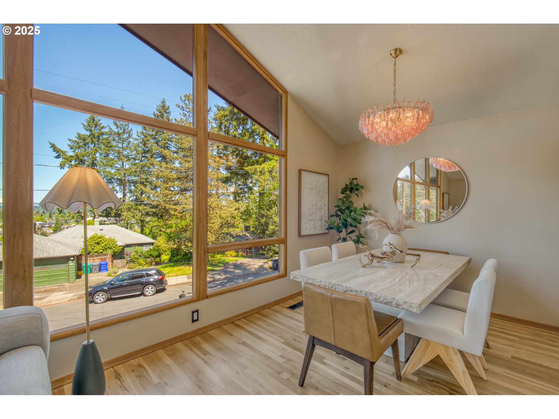 6950 Southeast Ash Street Portland, OR 97215 - Photo 8 of 45 a dining room with wooden floor a chandelier a wooden table and chairs