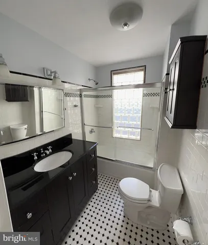 a bathroom with a granite countertop toilet sink and mirror