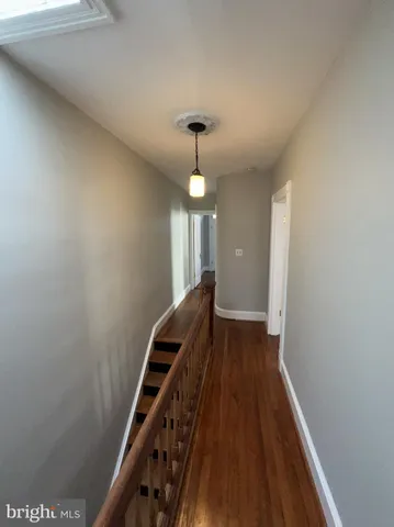 a view of a hallway with wooden floor and staircase
