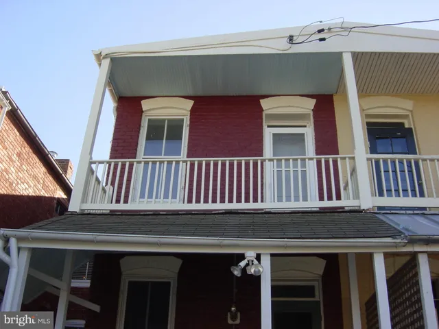a view of a brick house with wooden fence