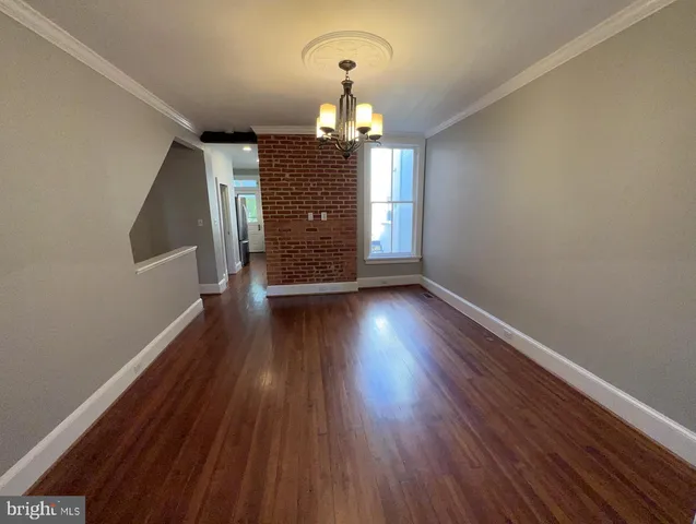 a view of a room with wooden floor chandelier and a window