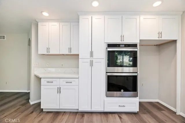 a kitchen with stainless steel appliances granite countertop a stove a microwave and a white cabinets