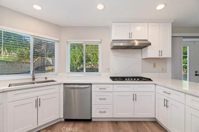 a kitchen with white cabinets and white appliances