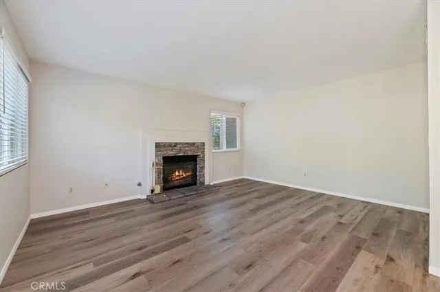 an empty room with wooden floor and fireplace