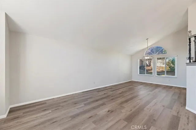 an empty room with wooden floor and window