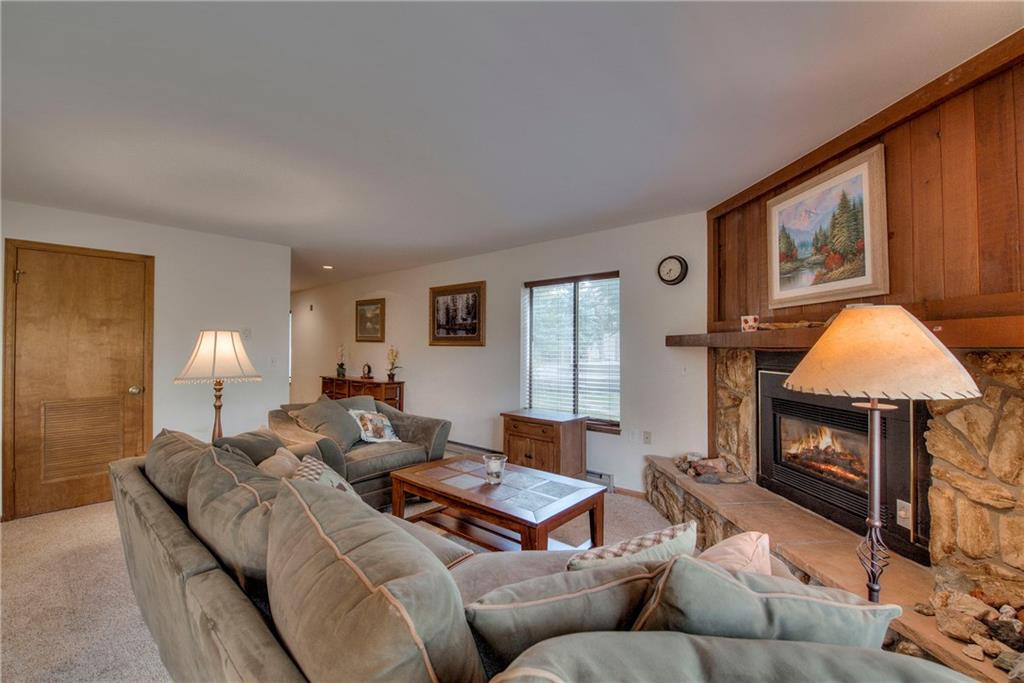 4811 Ryan Gulch Road, Unit 4811 Silverthorne, CO 80498 - Photo 12 of 35 a living room with furniture a window and a fireplace