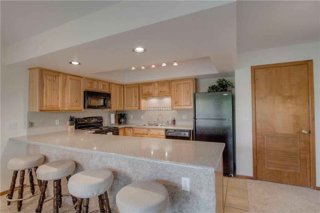 4811 Ryan Gulch Road, Unit 4811 Silverthorne, CO 80498 - Photo 13 of 35 a large kitchen with a table chairs refrigerator and a sink