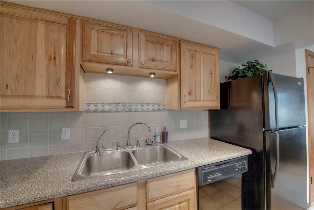 4811 Ryan Gulch Road, Unit 4811 Silverthorne, CO 80498 - Photo 16 of 35 a kitchen with stainless steel appliances granite countertop a refrigerator sink and cabinets