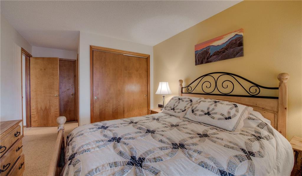 4811 Ryan Gulch Road, Unit 4811 Silverthorne, CO 80498 - Photo 21 of 35 a bedroom with a bed and a painting on the wall